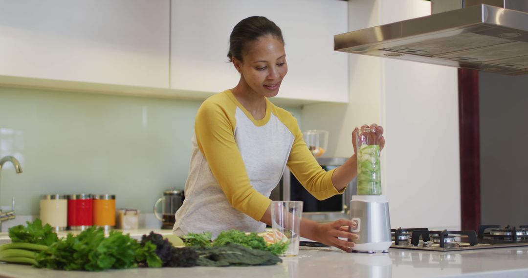 Woman blending fresh vegetables in modern kitchen - Free Images, Stock Photos and Pictures on Pikwizard.com