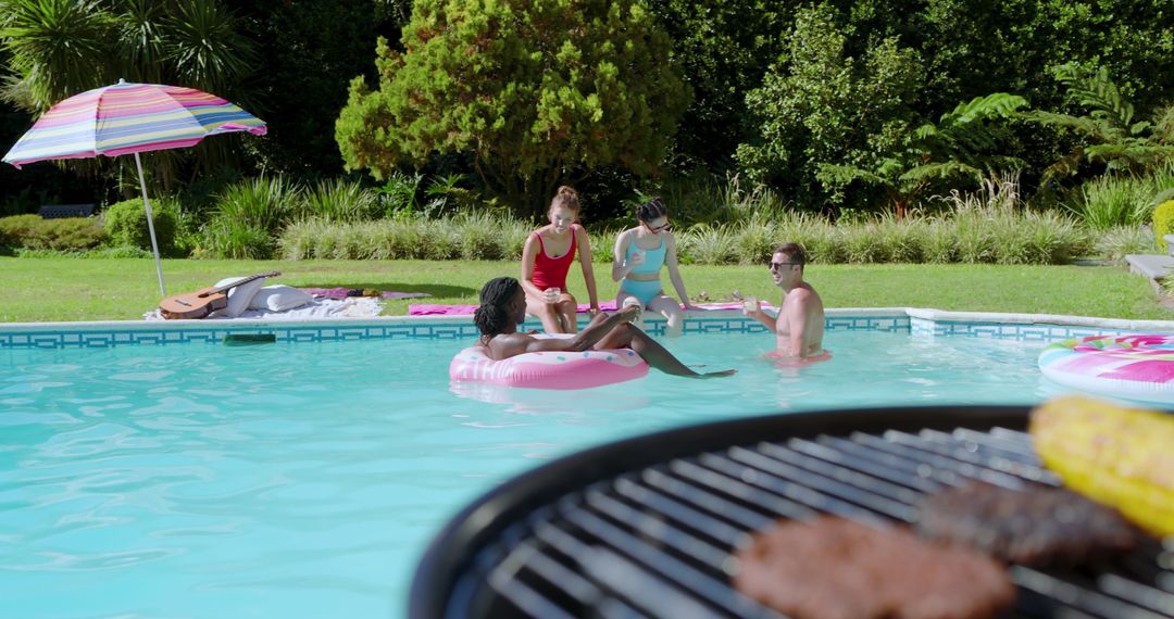 Friends Relaxing Poolside with Barbecue on Sunny Day