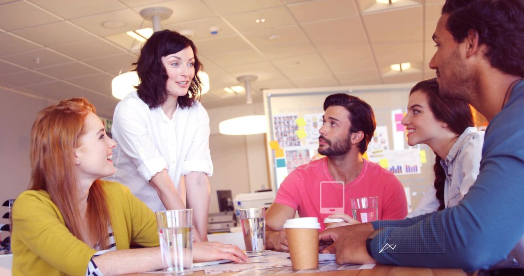 Team leader guiding creative team in collaborative brainstorming session at office table