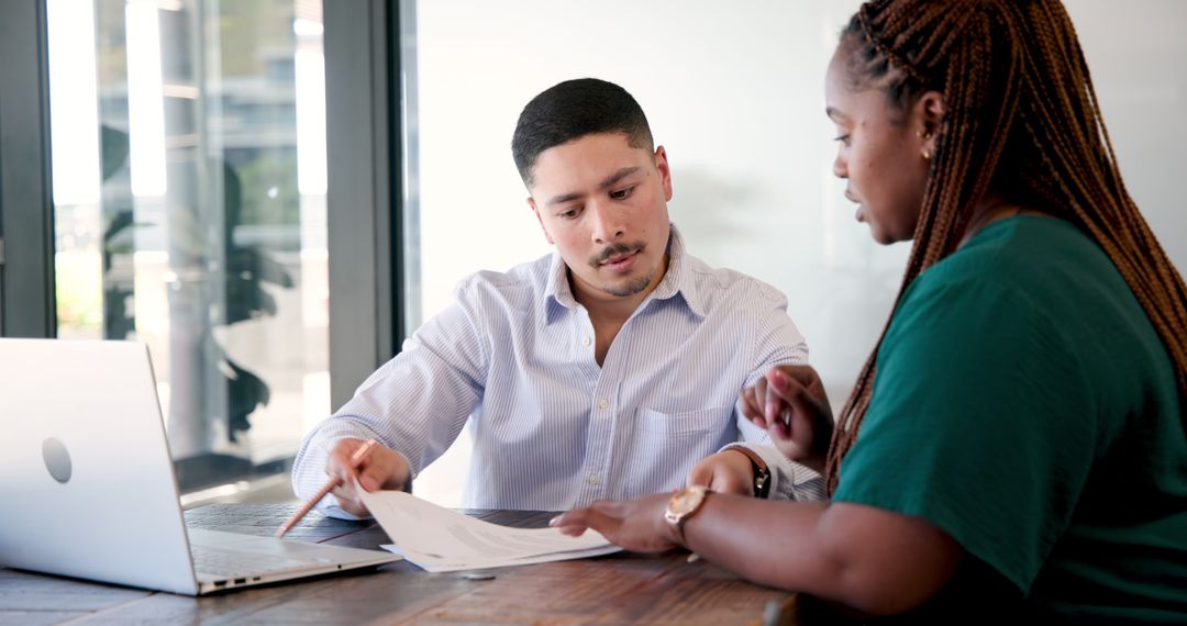 Colleagues Discussing Important Business Documents at Office Desk