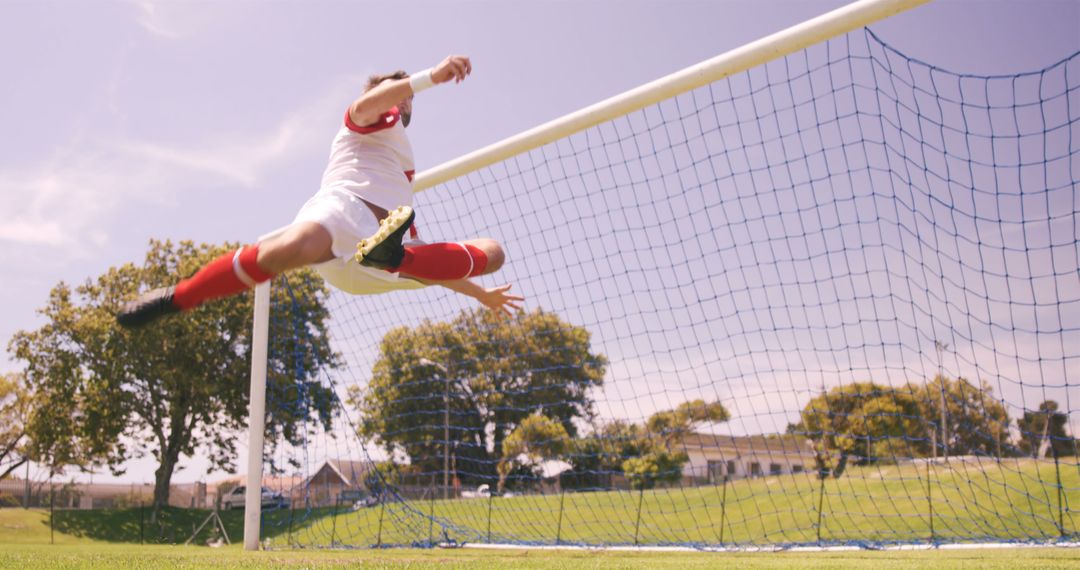 Soccer Player Scoring a Goal with Acrobatic Kick on Sunny Day - Free Images, Stock Photos and Pictures on Pikwizard.com