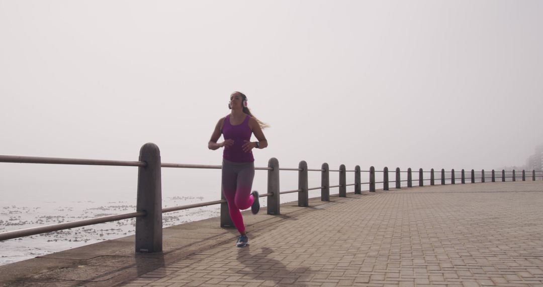 Woman Jogging on Coastal Pathway on Foggy Morning - Free Images, Stock Photos and Pictures on Pikwizard.com