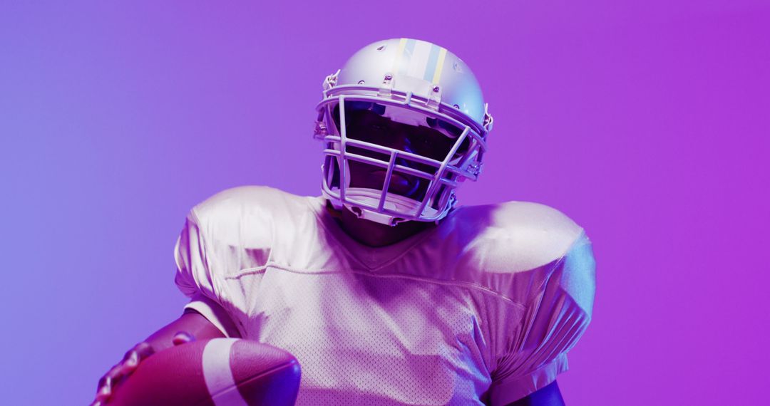 Image of african american american football player with ball over purple neon background - Free Images, Stock Photos and Pictures on Pikwizard.com