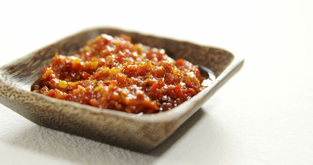 Close-Up of Spicy Red Sauce in Wooden Bowl on White Background - Free Images, Stock Photos and Pictures on Pikwizard.com