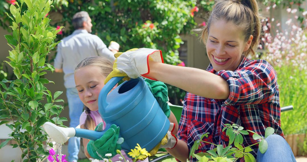 Smiling Mother and Daughter Watering Plants in Garden - Free Images, Stock Photos and Pictures on Pikwizard.com