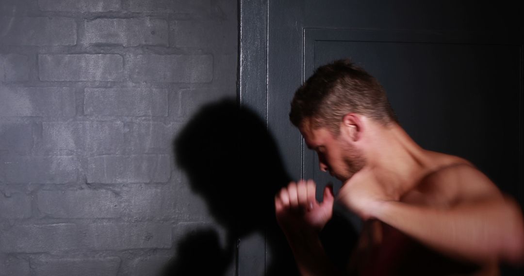 Man Sparing Shadow Boxing in Dark Room with Brick Wall - Free Images, Stock Photos and Pictures on Pikwizard.com