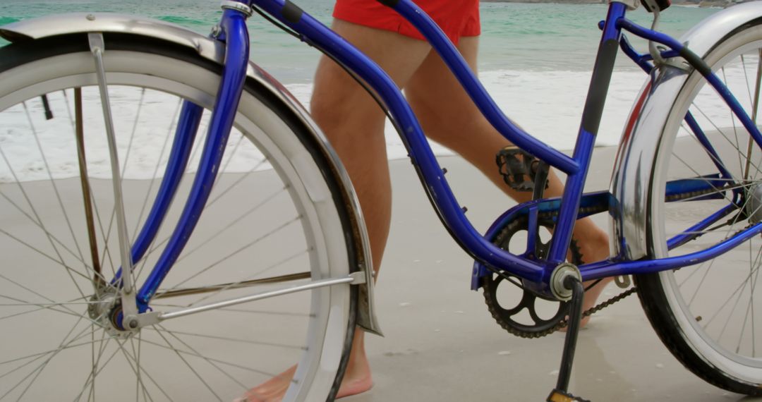 Man Walking Barefoot with Bicycle on Tranquil Beach