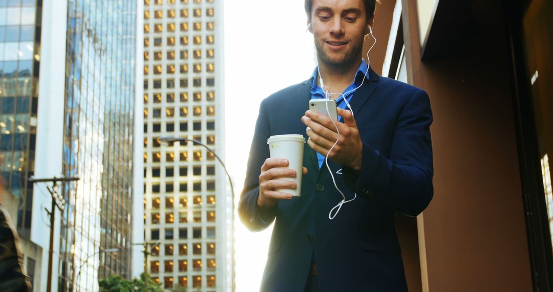 Businessman Walking in City Drinking Coffee and Using Smartphone - Free Images, Stock Photos and Pictures on Pikwizard.com