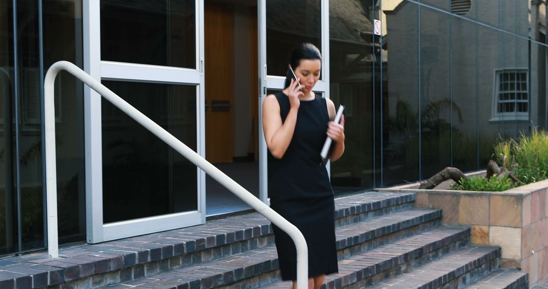 Businesswoman Walking Down Steps While Talking on Phone - Free Images, Stock Photos and Pictures on Pikwizard.com