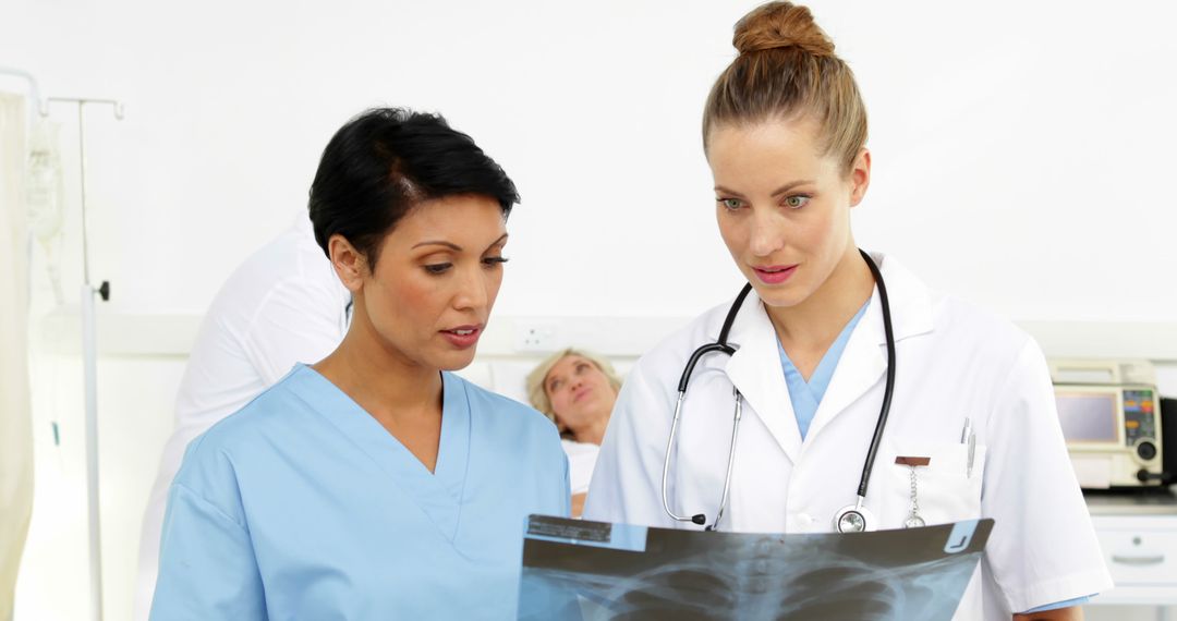 Healthcare Professionals Analyzing X-Ray Scan in Medical Facility - Free Images, Stock Photos and Pictures on Pikwizard.com