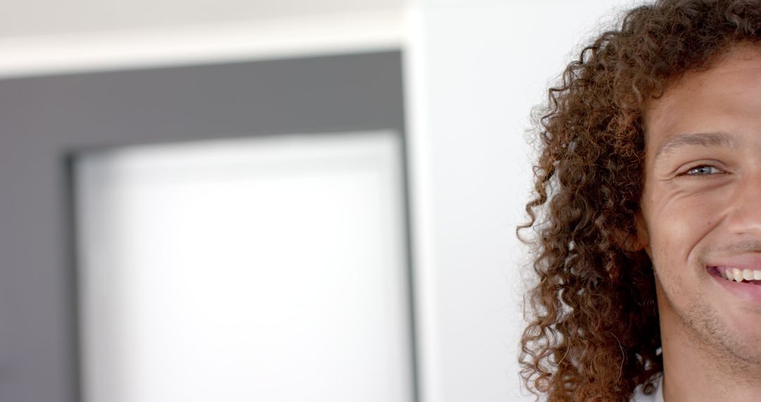 Smiling Young Biracial Man with Curly Hair and Copy Space