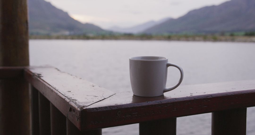 Calm Morning Coffee on Wooden Balcony Overlooking Serene Lake and Mountains - Free Images, Stock Photos and Pictures on Pikwizard.com