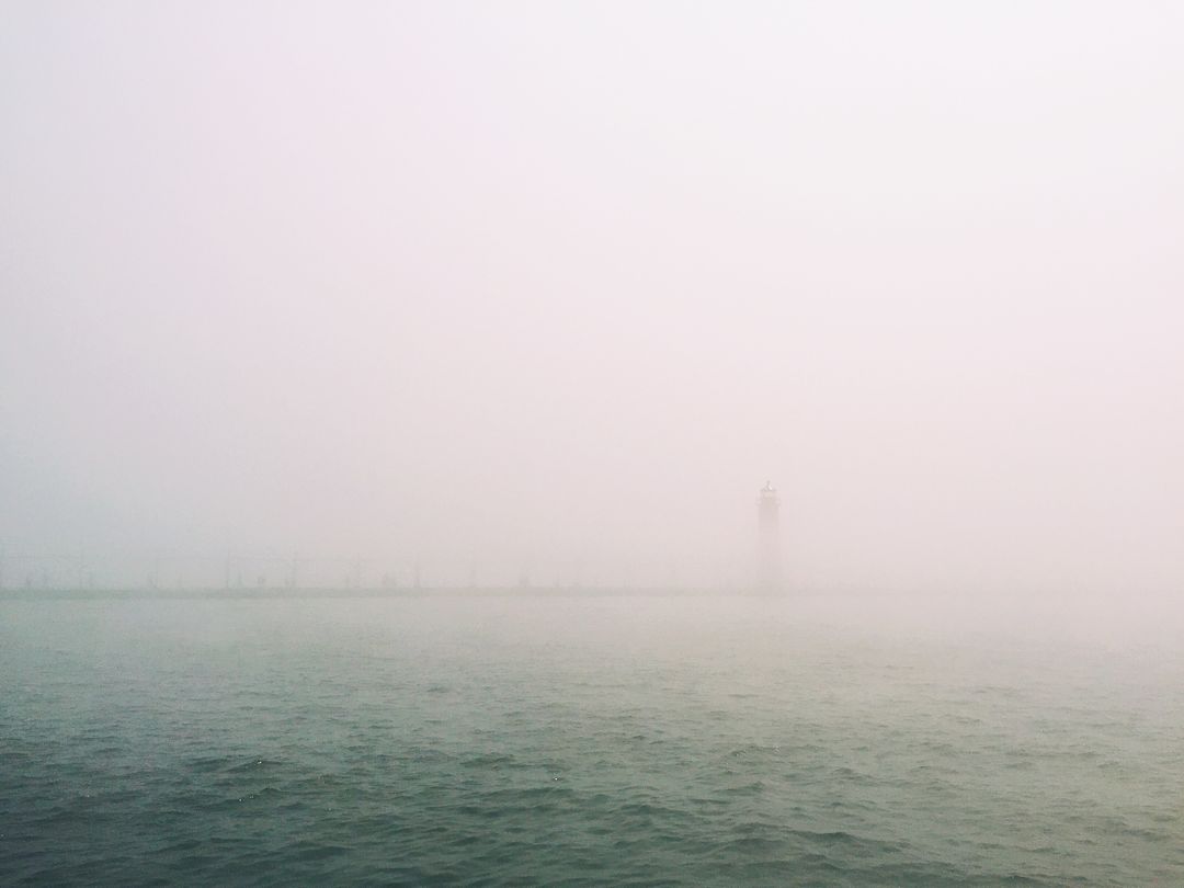 Lighthouse in Dense Fog on Tranquil Sea - Free Images, Stock Photos and Pictures on Pikwizard.com