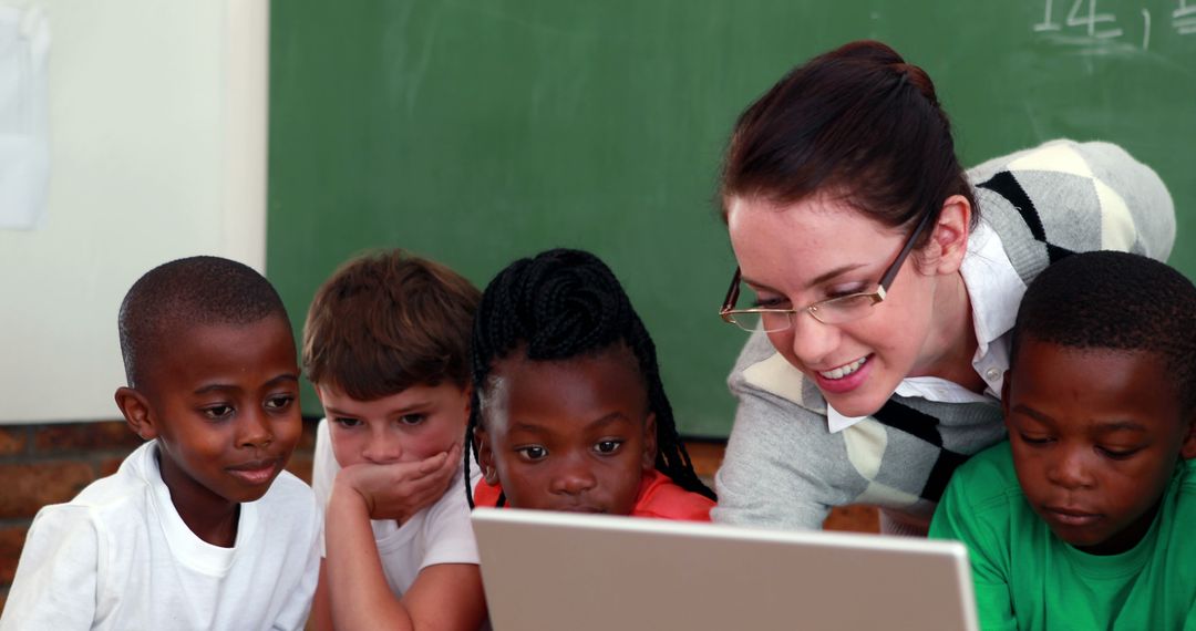 Smiling Teacher and Engaged Students Using Laptop in Classroom - Free Images, Stock Photos and Pictures on Pikwizard.com