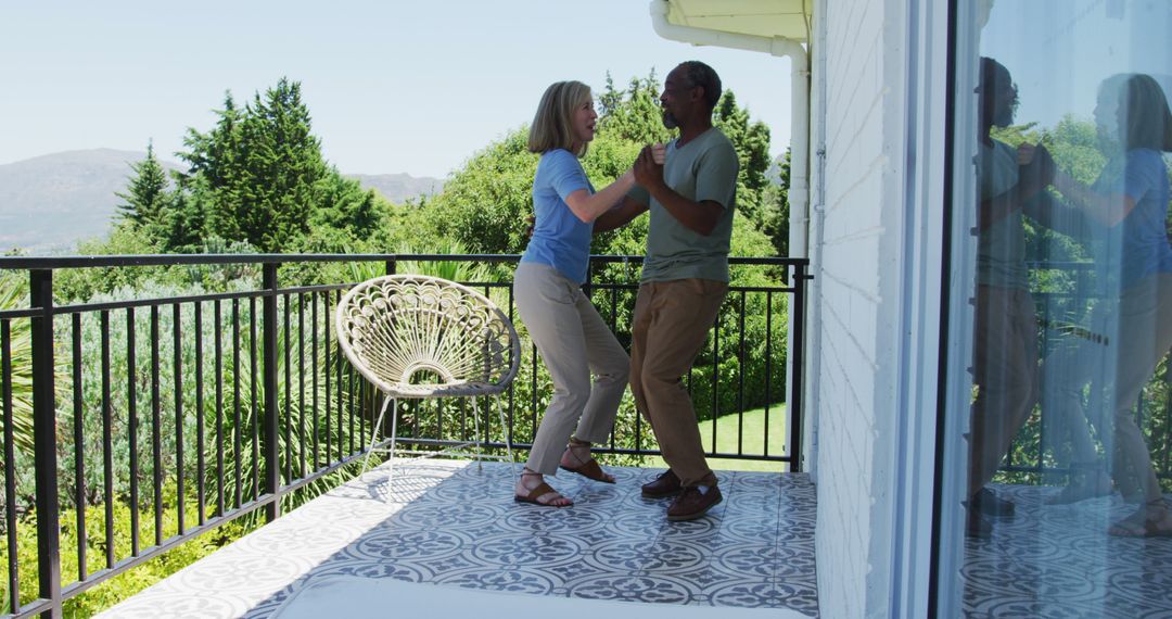 Biracial senior couple dancing together in the balcony at home - Free Images, Stock Photos and Pictures on Pikwizard.com