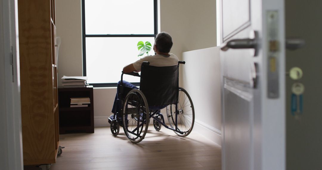 Elderly Male in Wheelchair Looking Out Window in Room - Free Images, Stock Photos and Pictures on Pikwizard.com