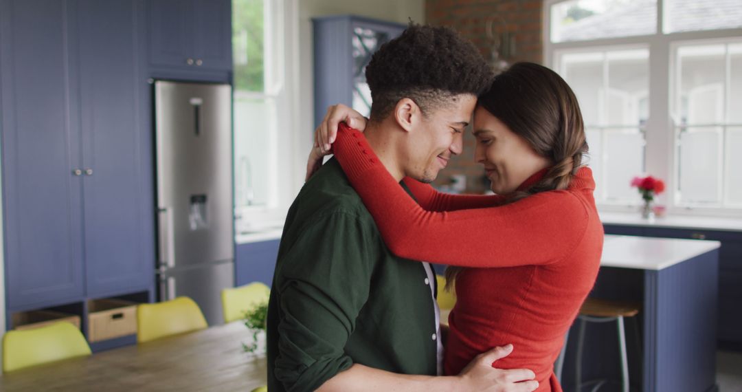 Joyful Biracial Couple Embracing in Modern Kitchen
