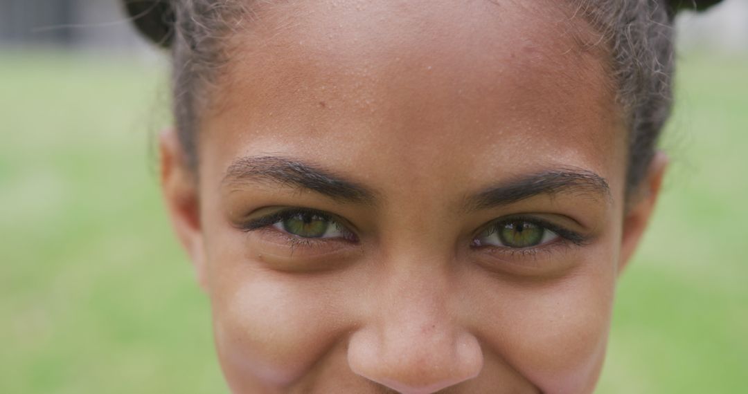 Close-Up Portrait of Smiling Biracial Girl with Green Eyes Outdoors - Free Images, Stock Photos and Pictures on Pikwizard.com