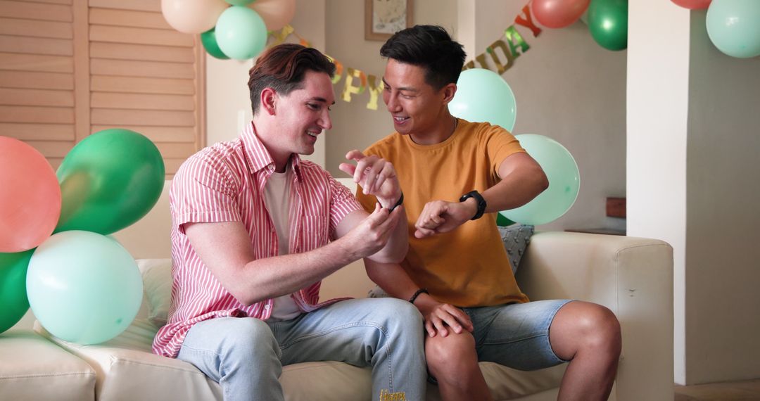 Gay Couple Exchanging Gifts and Laughing at Birthday Celebration