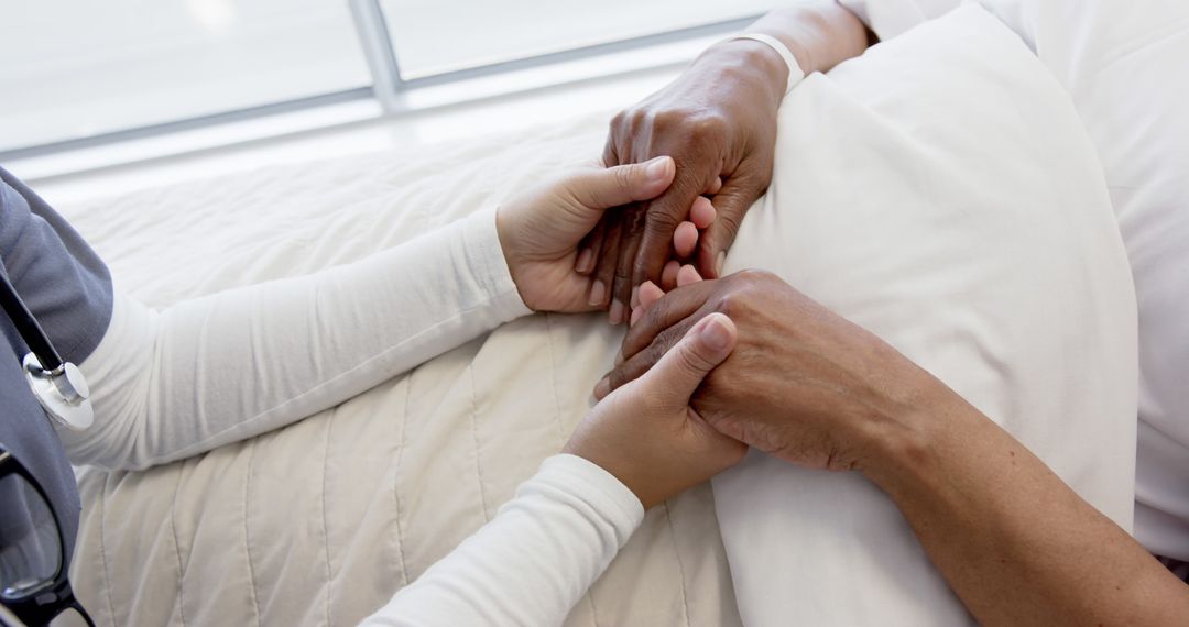 Nurse Comforting Patient by Holding Their Hand in Hospital Bed - Free Images, Stock Photos and Pictures on Pikwizard.com