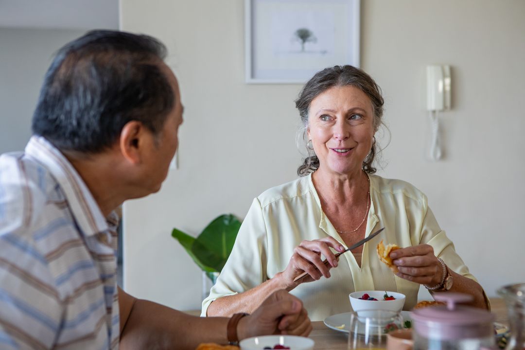Senior Couple Enjoys Breakfast Together Sharing Berries and Pastry