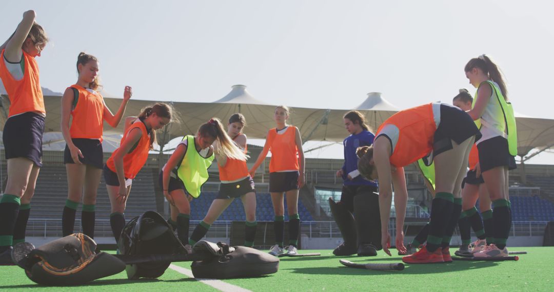 Female Field Hockey Team Preparing for Practice in Sunny Stadium - Free Images, Stock Photos and Pictures on Pikwizard.com