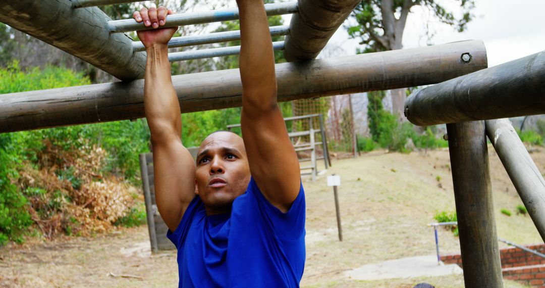 Determined man training on monkey bars in outdoor fitness park - Free Images, Stock Photos and Pictures on Pikwizard.com