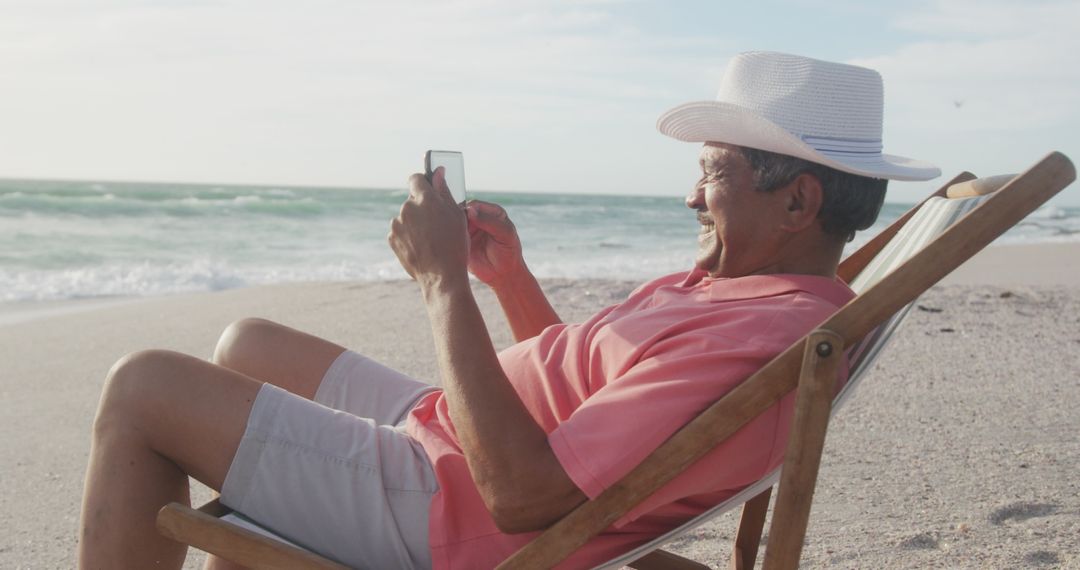 Senior Man Enjoying Beach with Smartphone in Hand