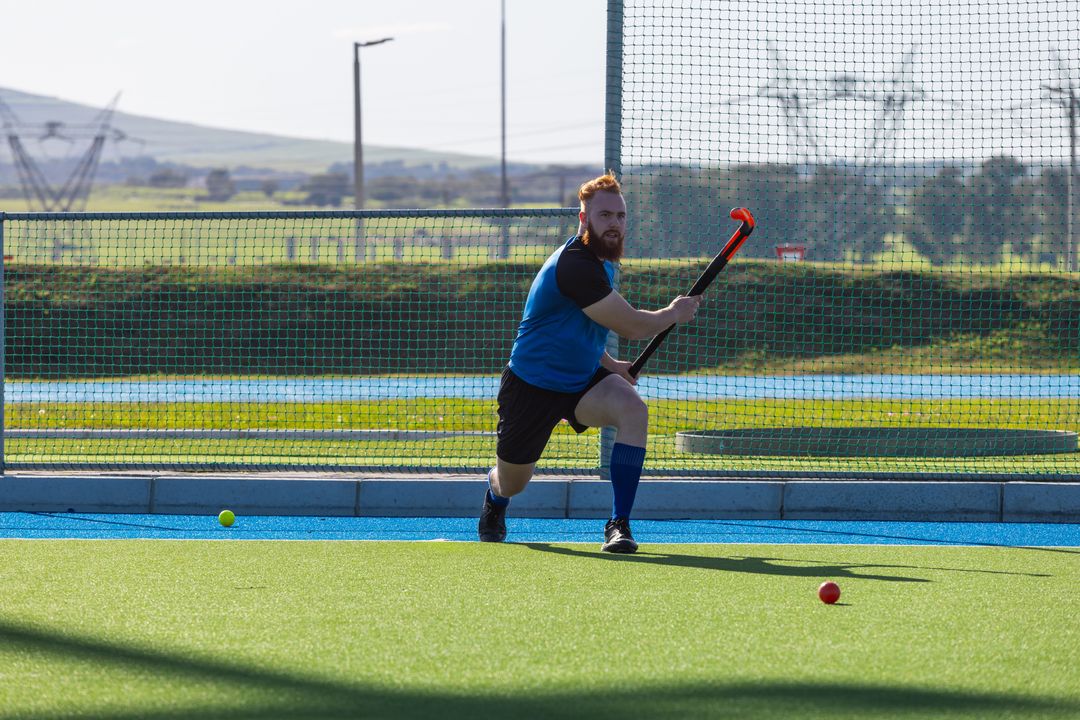 Male Hockey Player Aiming at Ball on Field with Intensity