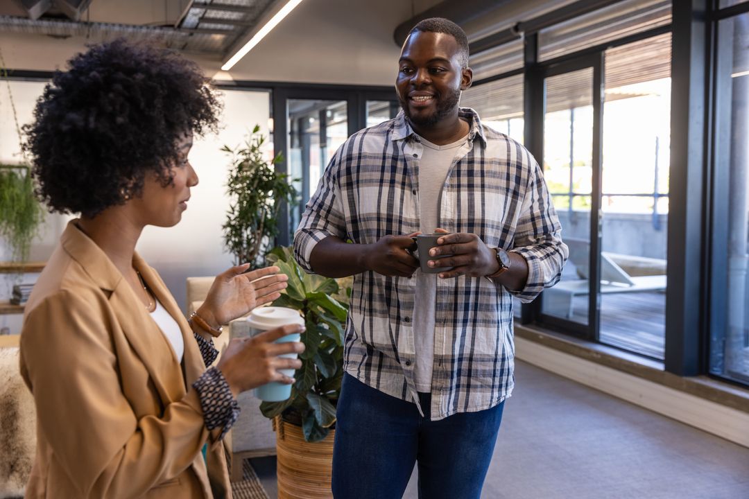 Diverse Colleagues Engaging in Workplace Discussion with Drinks