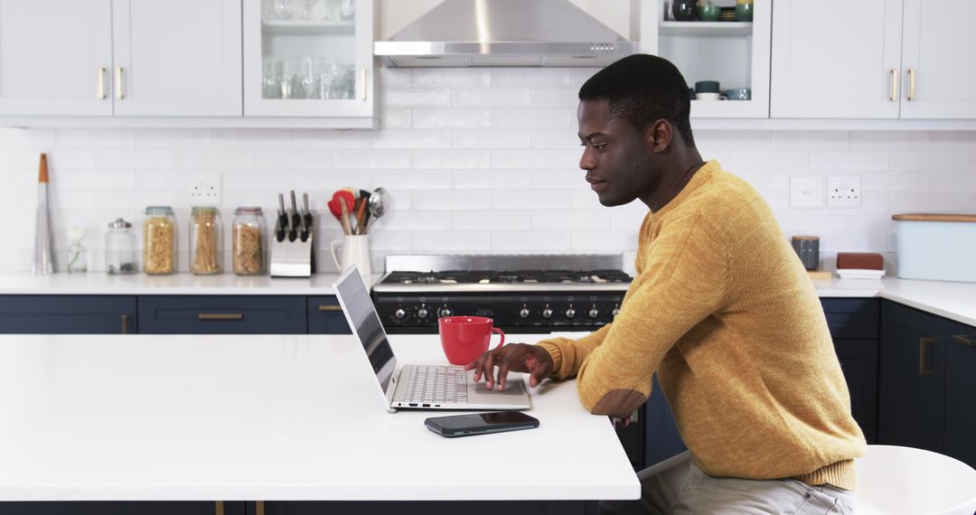 Professional Man Working on Laptop in Modern Kitchen