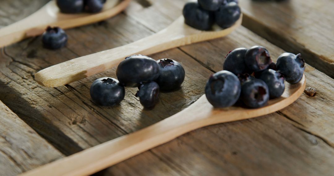 Fresh Blueberries on Wooden Spoons Positioned on Rustic Wooden Table - Free Images, Stock Photos and Pictures on Pikwizard.com