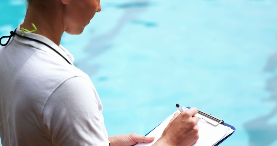 Lifeguard Taking Notes by Pool for Safety Management - Free Images, Stock Photos and Pictures on Pikwizard.com