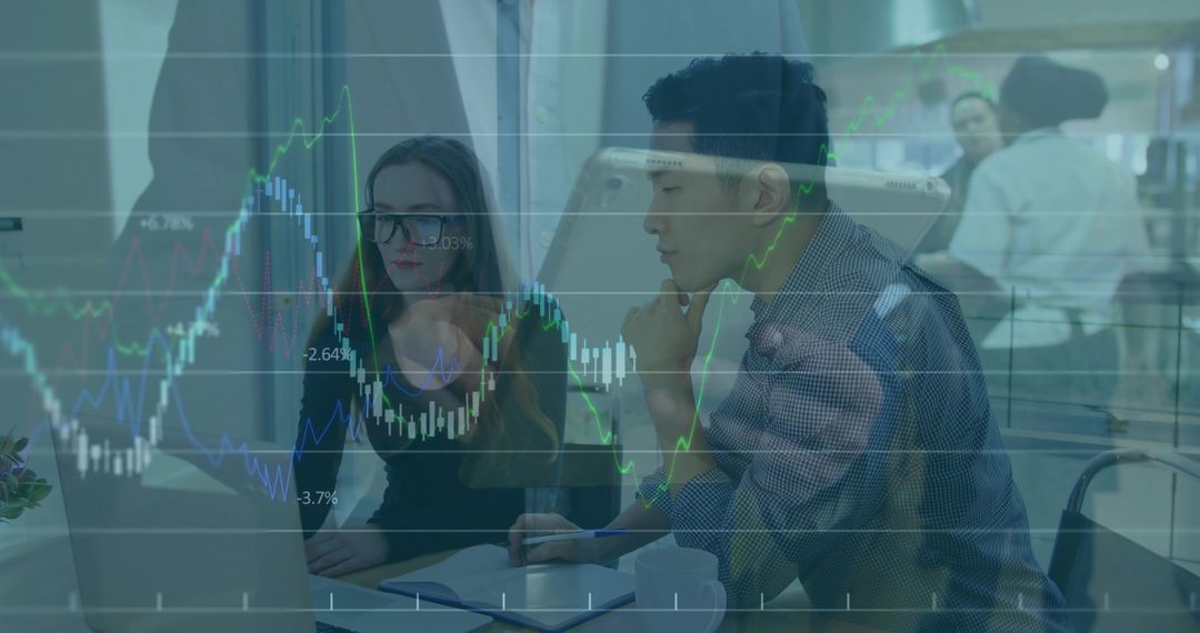Colleagues Analyzing Financial Data on Laptop with Chart Overlay