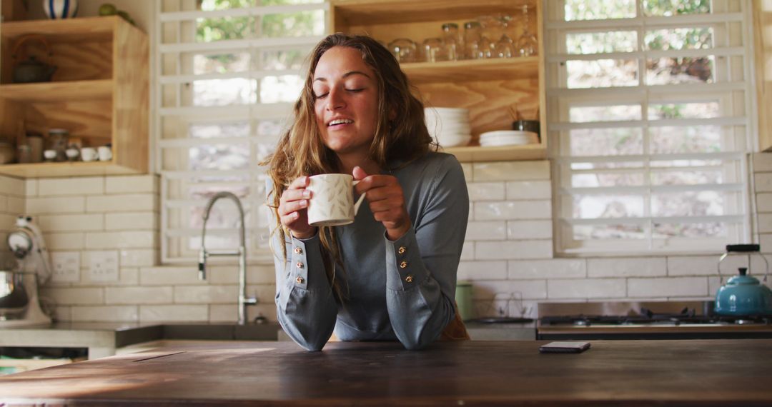 Young Woman Enjoying Morning Coffee in Bright Kitchen - Free Images, Stock Photos and Pictures on Pikwizard.com