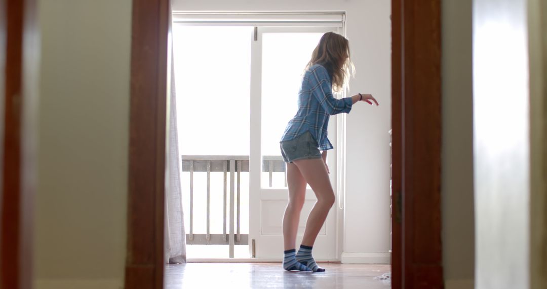 Young Woman Dancing Joyfully in Casual Bedroom - Free Images, Stock Photos and Pictures on Pikwizard.com