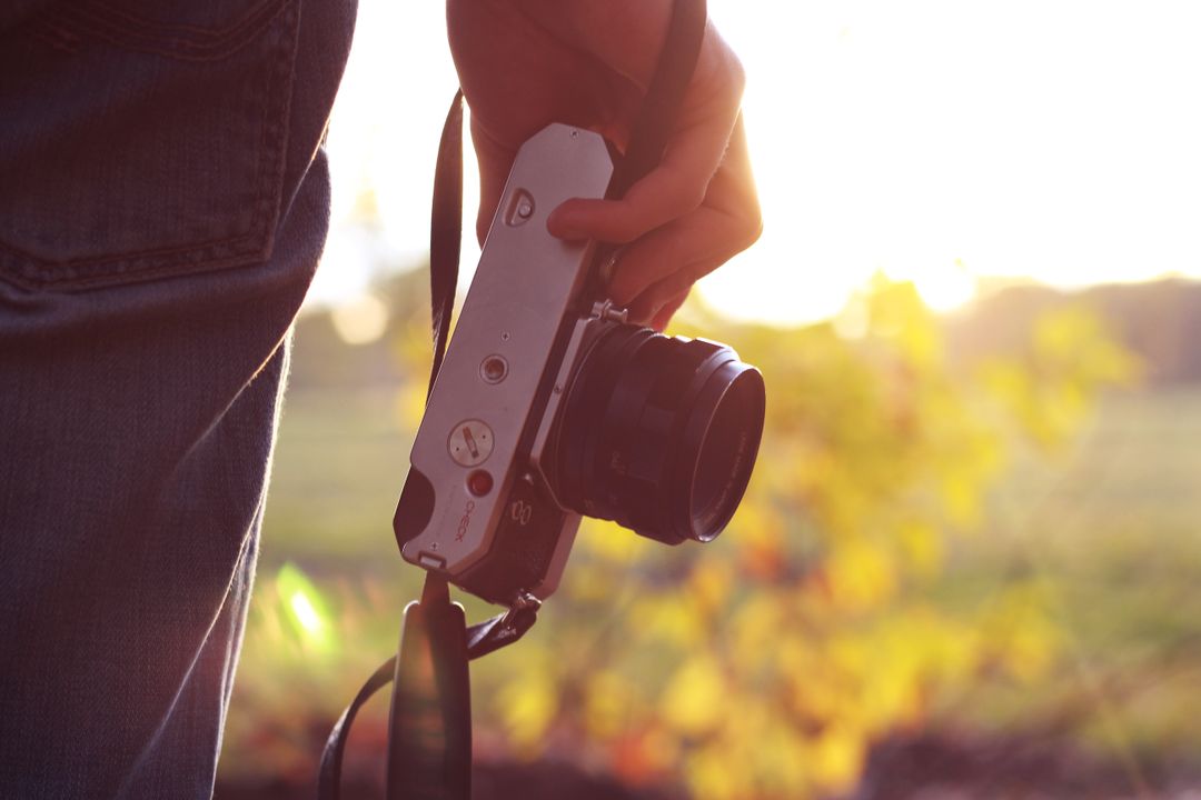 Close-up of Person Holding Vintage Camera in Sunset Light - Free Images, Stock Photos and Pictures on Pikwizard.com