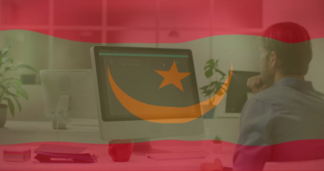 Professional Working on Computer with Flag Overlay in Modern Office