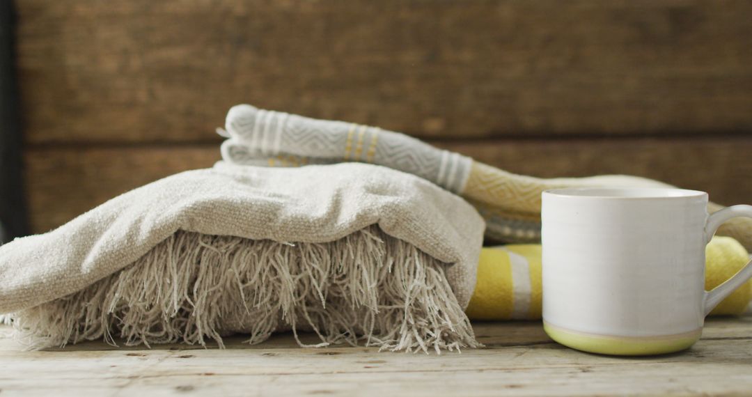 Image of folded blankets and cup of tea on wooden background - Free Images, Stock Photos and Pictures on Pikwizard.com