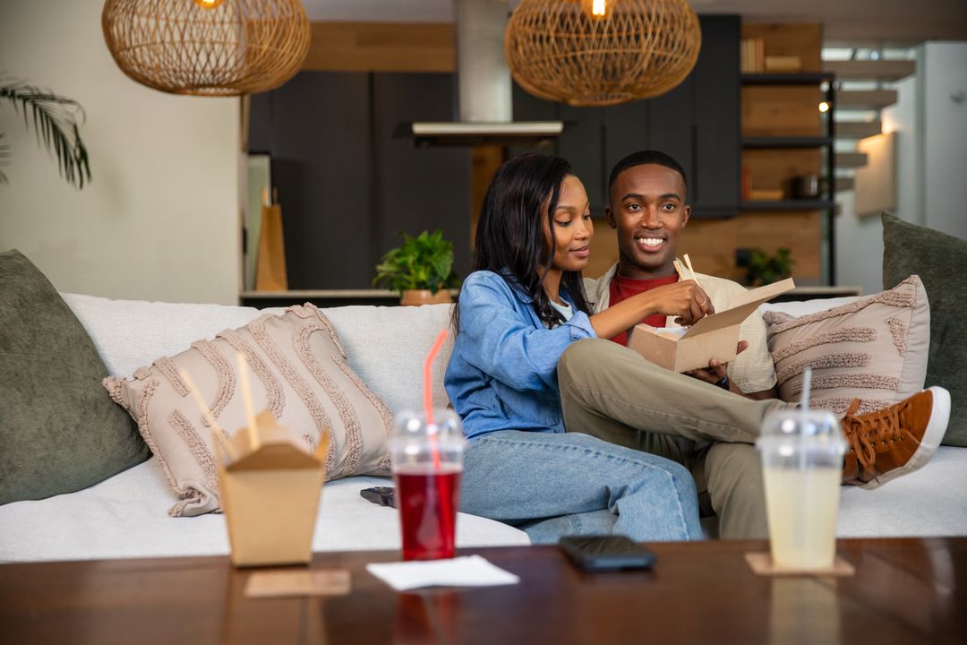 Couple Enjoying Takeout on Comfortable Sofa in Modern Living Room