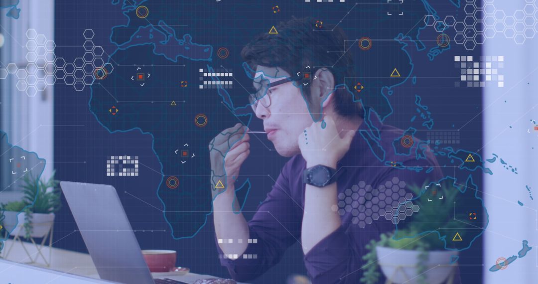 Asian Man Engaged in Global Business Network Analysis on Laptop
