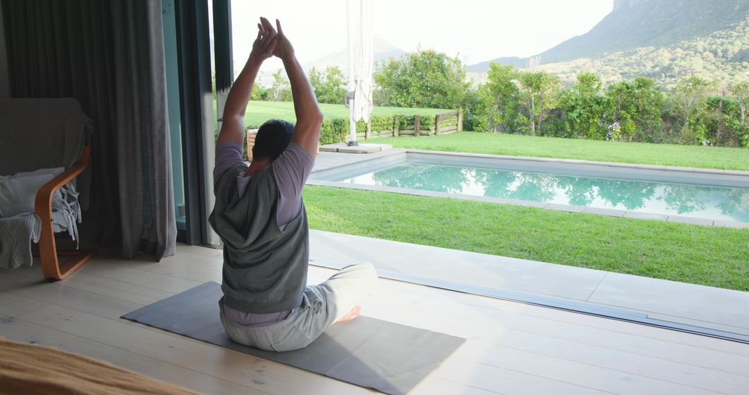 Asian Man Meditating by Pool with Mountain View