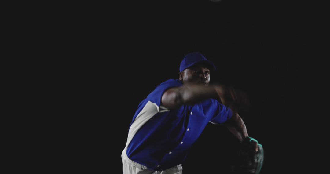 Baseball Pitcher in Action Wearing Blue Uniform Against Dark Background - Free Images, Stock Photos and Pictures on Pikwizard.com