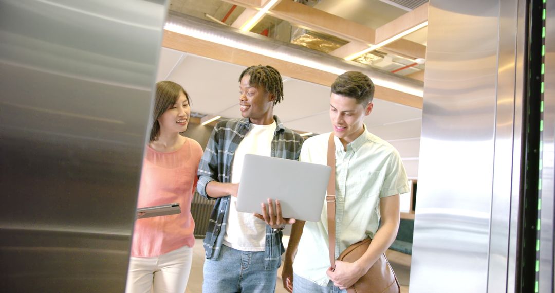 Diverse Professionals Collaborating in Modern Office with Laptop