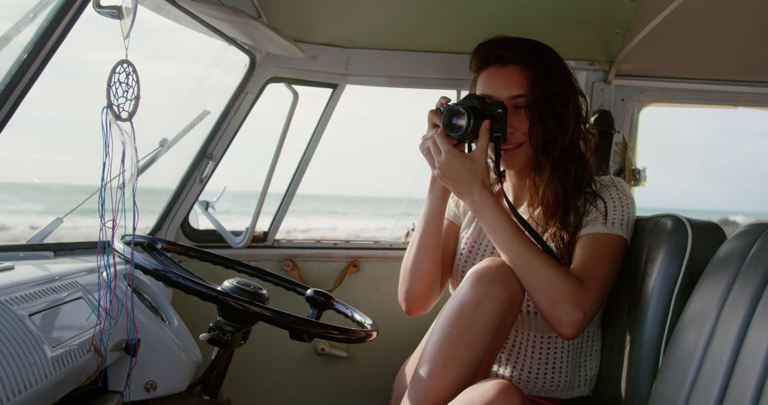 Woman taking photo by beach inside vintage van - Free Images, Stock Photos and Pictures on Pikwizard.com