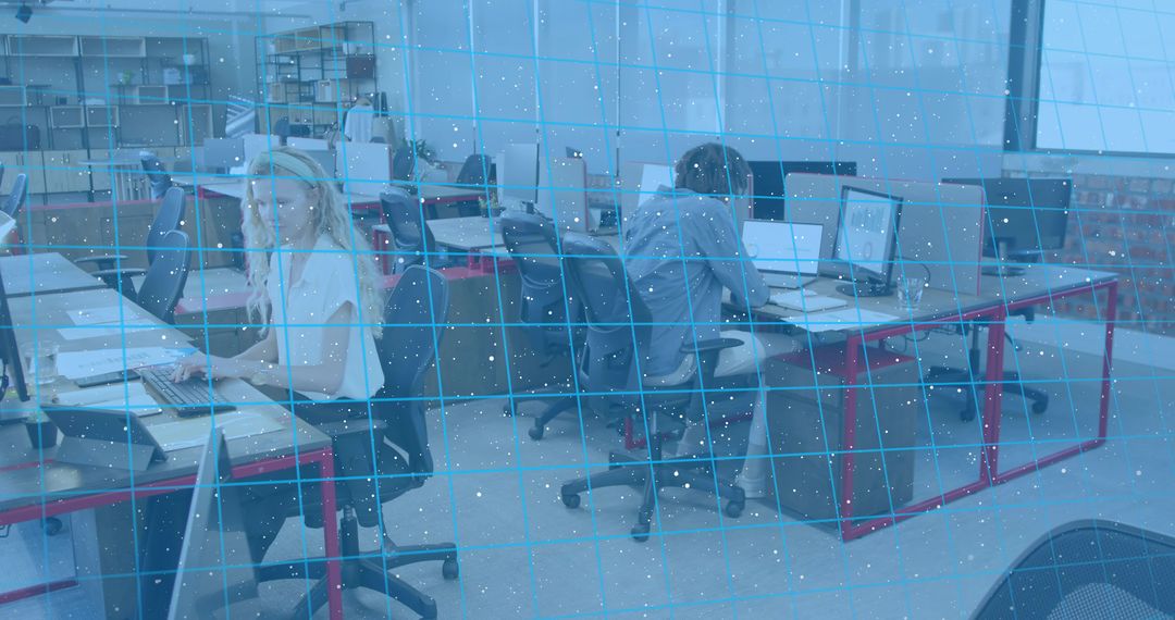 Woman typing in bright coworking office with laptops and red desks, collaborative workspace