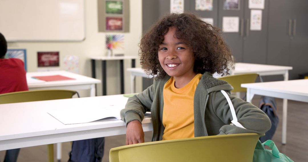 Smiling Student in Classroom with Writing Stationery
