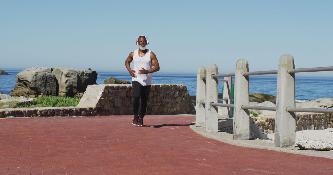 Active Senior Man Jogging by Ocean for Healthy Lifestyle - Free Images, Stock Photos and Pictures on Pikwizard.com