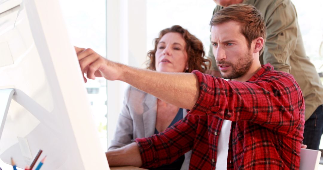 Focused Colleagues Collaborating on Project in Bright Office