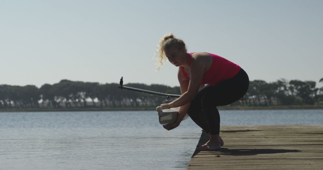 Woman Collecting Water Samples with Stick on Lake Dock - Free Images, Stock Photos and Pictures on Pikwizard.com